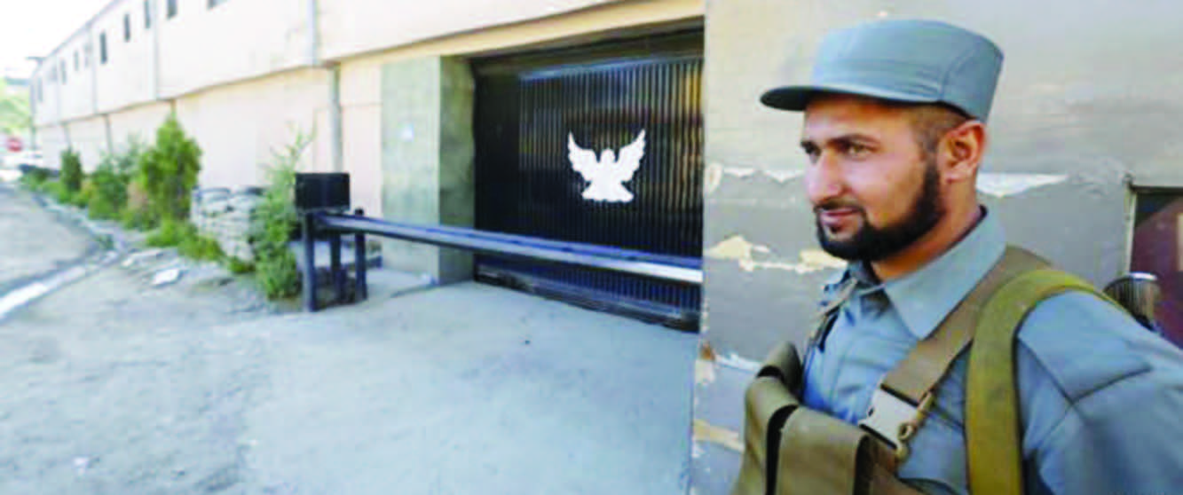 An Afghan policeman guards the gate of a guesthouse after an attack the previous night in which 14 civilians were killed, in Kabul, May 14, 2015.