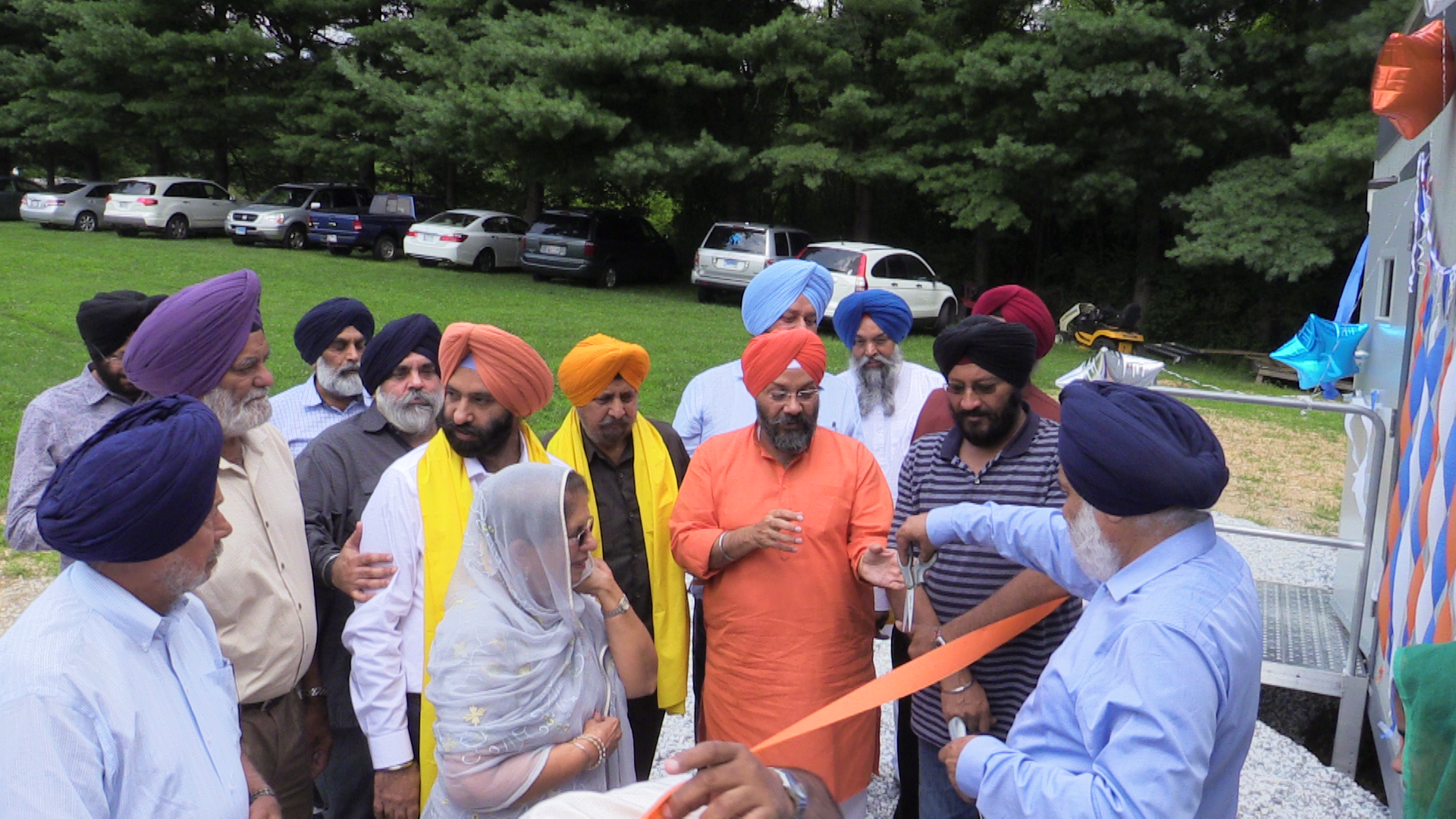 Inauguration. Dr. Surinder S Gill (back to camera) passing over a pair of scissors for Dr. Kirpal Kaur, Trustee of Gurudwara Sikh Association of Baltimore and Manjit Singh GK, President, DSGPC, to inaugurate the school. Seen are community leaders who helped in raising the school which included Gurudwara Sikh Association of Baltimore President Jeet Singh and Chairman K. K. Sidhu.