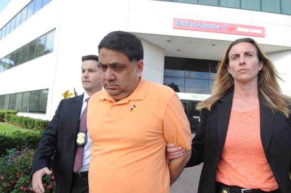 Harendra Singh is led out of the FBI office in Melville early Wednesday, Sept. 9, 2015.