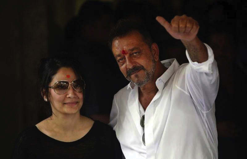 Sanjay Dutt, right, shows a thumbs up sign along with his wife Maanyata after arriving at his residence in Mumbai. Photo courtesy: AP