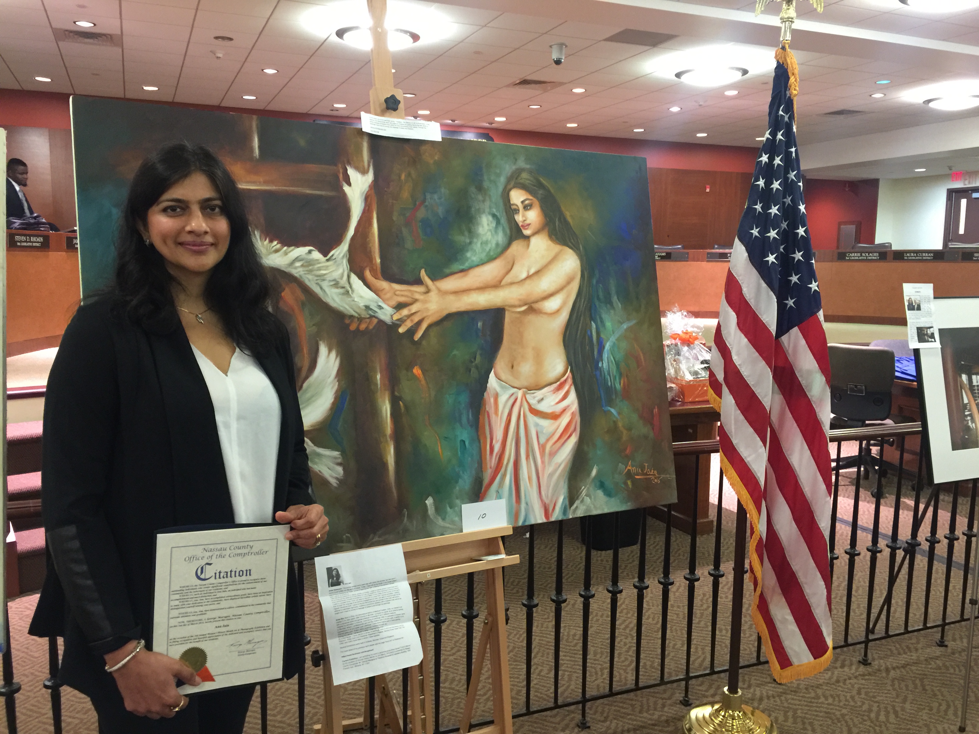 Anu Jain poses with her award in front of her entries in the exhibition