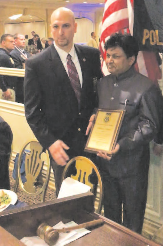 Dhiren Amin with his award. To his right is Michael Manzo.