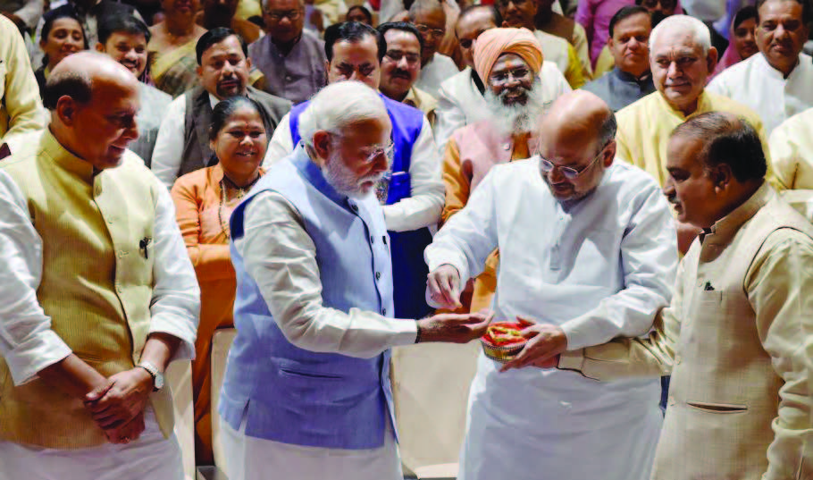 BJP president Amit Shah (right) offers sweets from the Tirupati temple to Prime Minister Narendra Modi as home minister Rajnath Singh looks on during the BJP parliamentary party meeting in New Delhi on March 16.